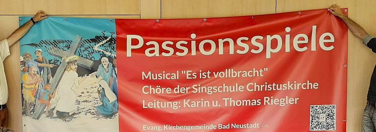Thomas Riegler und Tobias Germeshausen mit dem Banner zum Kindermusical "Es ist vollbracht"