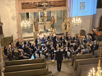 Christoph Schindler gibt dem Dekanatsposaunenchor den Einsatz am 25.10.2026 in der Kirche St.Michael zu Ostheim vor der Rhön
