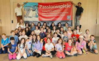 Die Singschule der Christuskirche Bad Neustadt an der Saale mit dem Banner zum Kindermusical "Es ist vollbracht"